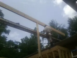 Carpenter setting a ridge beam over a new addition frame — Ice Dam Removal by Roofing Brothers in Williamsport