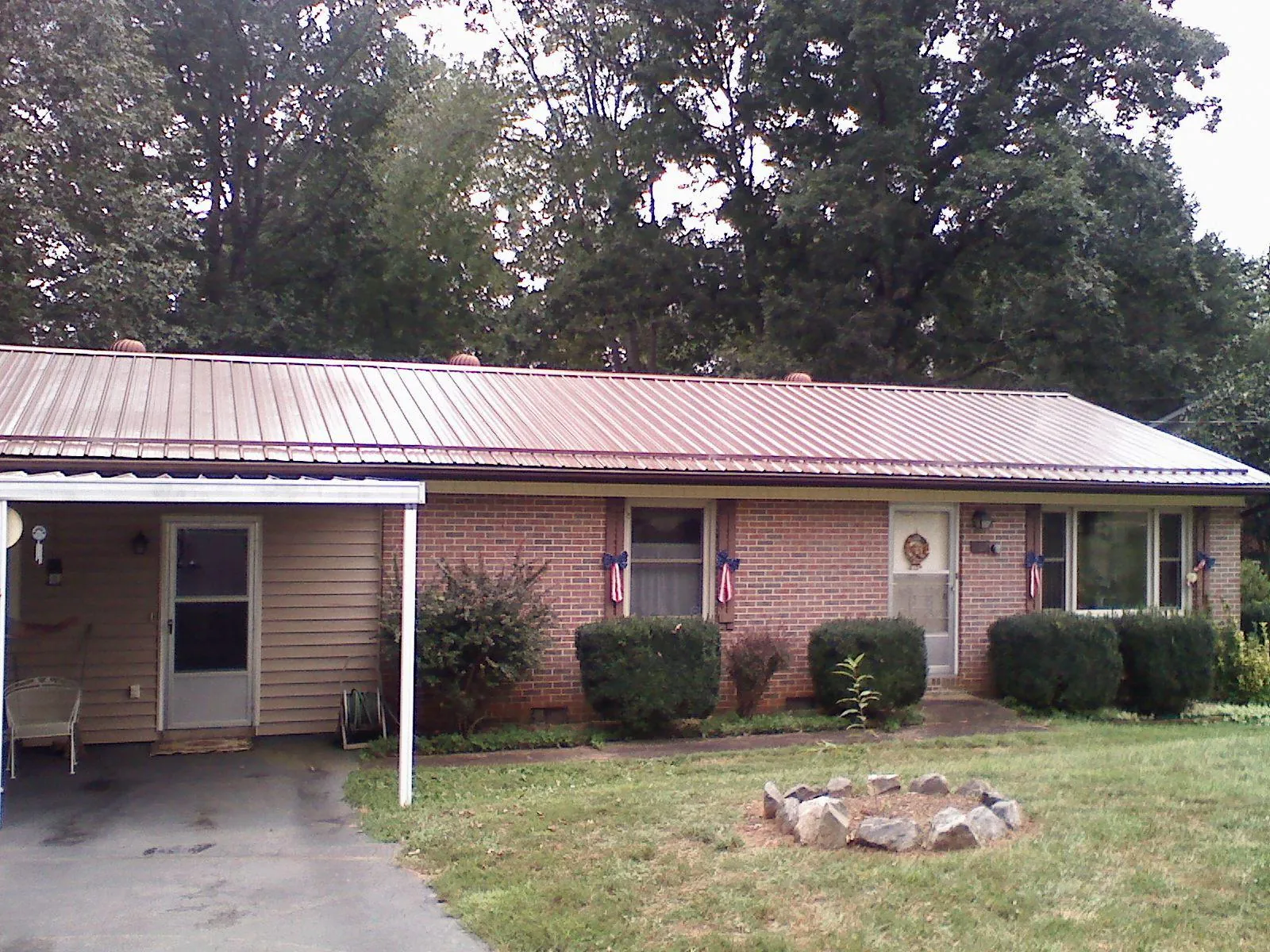 Bronze metal roof and carport on a brick ranch home — Roof Repair work by our crew in Williamsport